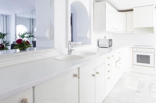 阿尔姆尼卡阿尔拜辛德尔马套房酒店的白色的厨房配有白色橱柜和水槽