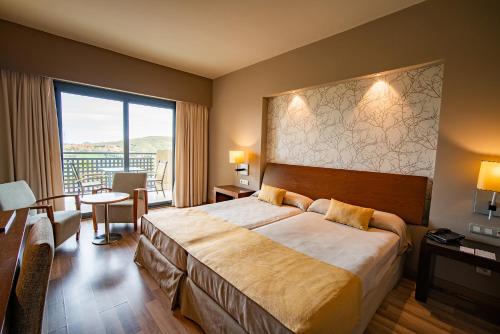 维拉埃斯特山谷高尔夫度假酒店的一间酒店客房,设有一张大床和一个大窗户