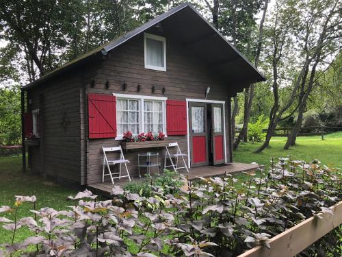 Skulte夏日度假屋的一个带红色门的小小屋和种有鲜花的花园