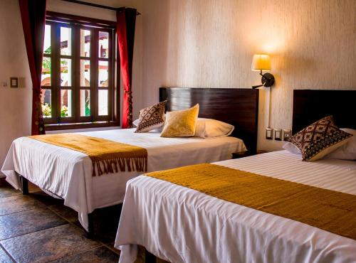 图斯特拉古铁雷斯Hotel Casa del Agua的酒店客房设有两张床和窗户。
