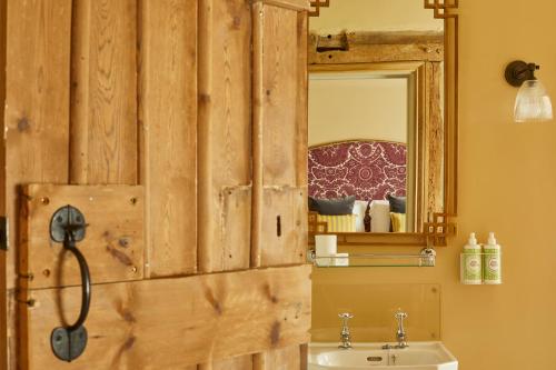 马尔堡Crown and Anchor的浴室设有木墙、水槽和镜子