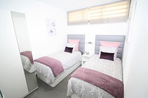 英格兰海滩Fantastic apartment with sea views的一间卧室设有两张床和窗户。