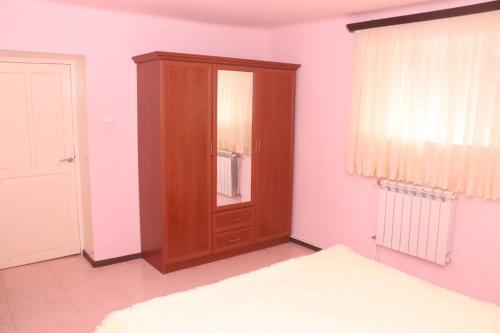 埃里温Уютные апартаменты в малом центре Еревана的卧室配有木制橱柜,位于床边