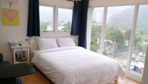 冬山乡梅花湖 轉角民宿的卧室设有白色的床和大窗户