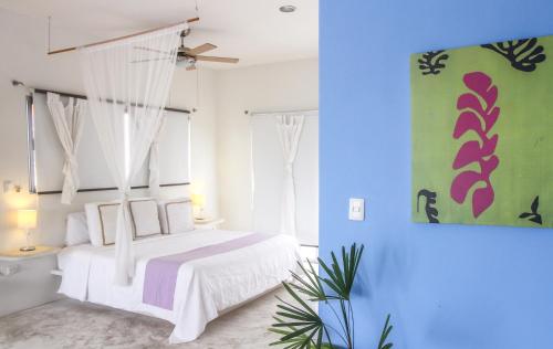 图卢姆双子座别墅精品公寓式酒店的卧室配有白色的床和蓝色的墙壁