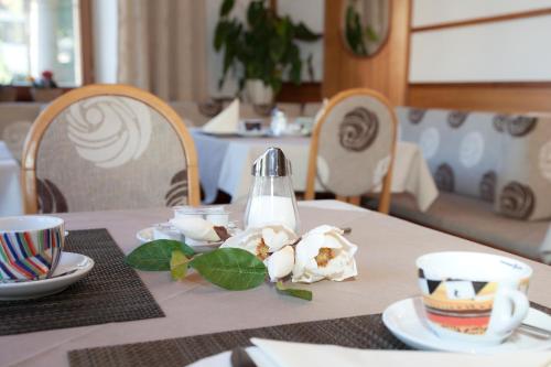 奥茨塔尔Hotel Garni Gletschertor的一张桌子,上面有白色的桌布和杯子