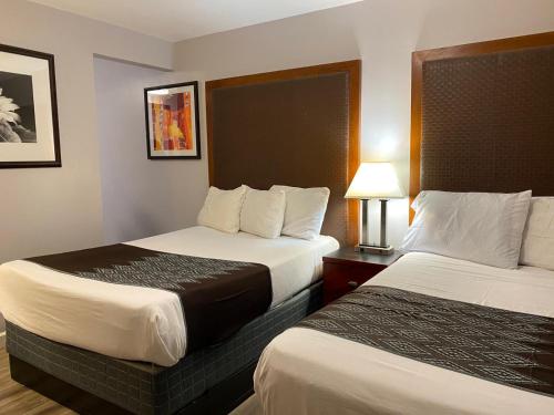 圣玛丽亚克罗尼尔汽车旅馆的酒店客房,设有两张床和一盏灯