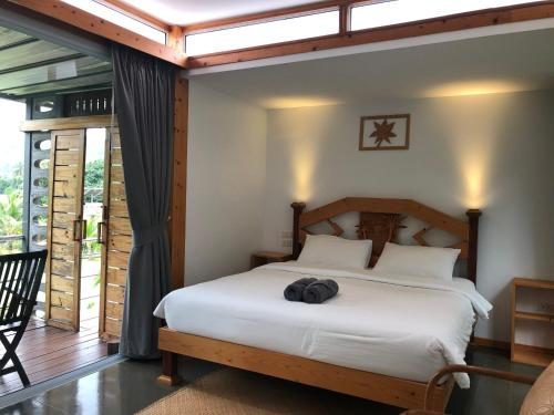 湄南海滩Baan Boom Boxes Eco Friendly Resort的卧室配有白色的床和木制床头板