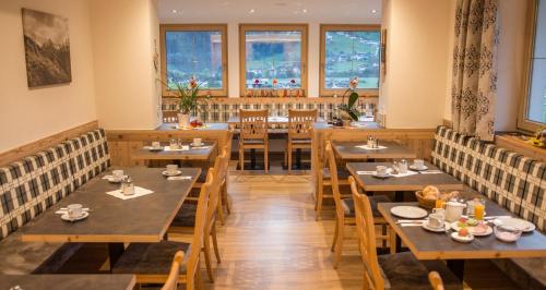 施文道缇波特斯克旅馆的餐厅设有木桌、椅子和窗户。