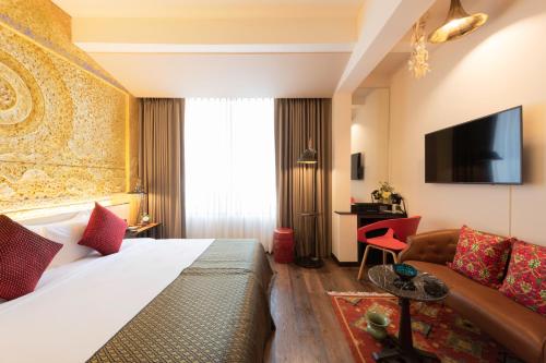 曼谷Dhevi Bangkok Hotel的酒店客房,配有床和沙发