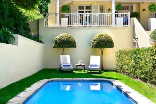弗朗斯胡克达妮埃拉酒店的后院设有游泳池、两把椅子和一所房子