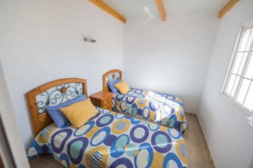 塔拉哈勒赫Tarajalejo Sun & Relax的一间卧室设有两张床和两个窗户。