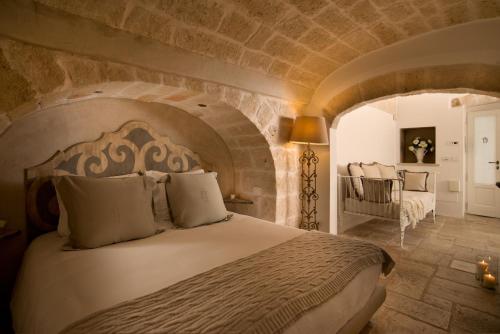莫诺波利Hotel Don Ferrante的一间卧室设有一张带石墙的大床