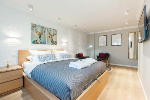 阿特劳Avangard Aparts - Avangard的一间卧室配有一张带蓝白色床单的大床