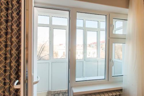 阿特劳Avangard Aparts - Avangard的一间设有玻璃门和窗户的房间