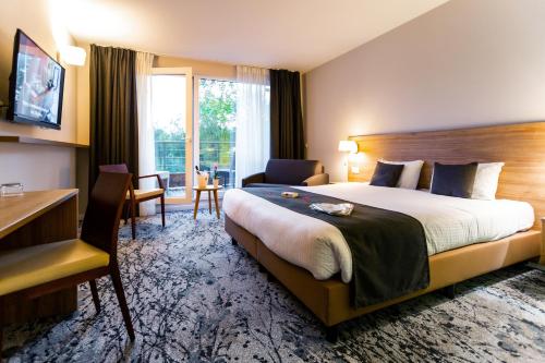 蒙斯Utopia Hotel - Art & Nature Hotel的酒店客房设有一张大床和一张书桌。
