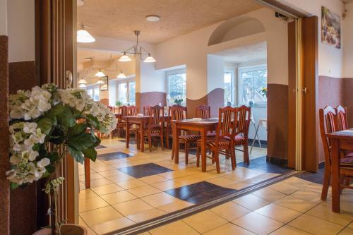 弗伦斯堡诺德格酒店的一间带桌椅和鲜花的用餐室