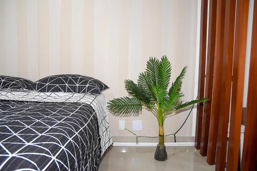 萨尔瓦多Bahia Flat ap. 311的卧室配有黑白床和植物