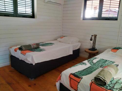 克拉伦代克红棕榈度假村的白色墙壁客房的两张床