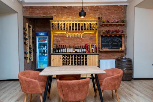 第比利斯Hotello的酒吧配有桌椅和葡萄酒瓶