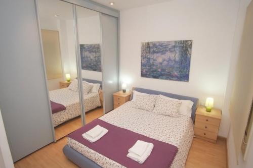 巴塞罗那Lovely Apartment at Park Güell的一间卧室配有两张床和镜子