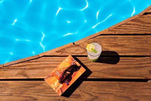 帕罗奇亚卡萨蒂罗姆酒店的坐在游泳池旁的桌子上喝一杯