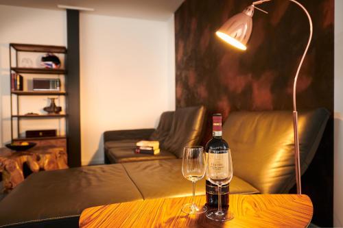 汉诺威City Apartments Hannover的桌子上放有一瓶葡萄酒和两杯酒
