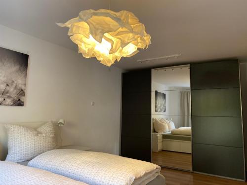因斯布鲁克Wohne im Grünen/Innsbruck/4 Pax的一间卧室配有一张床和一个吊灯