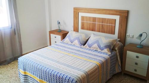 罗塔APARTAMENTO VILLA DE ROTA - VISTA MAR, 135m2, Terraza, SAT TV y más的一间卧室配有一张蓝色和黄色毯子的床