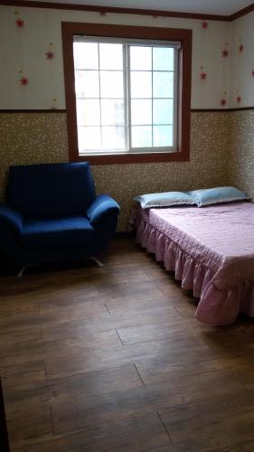 保宁市Daecheon Ocean Hill Pension的一间卧室配有一张床、一张沙发和一个窗口