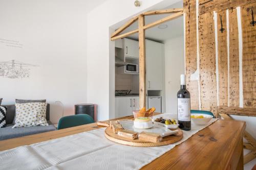 里斯本Graça Charming Apartment的一张桌子,上面放着一瓶葡萄酒和水果