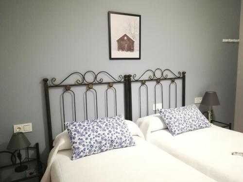 CastronuñoEl Balcón del Duero 1—2的一间卧室配有两张带白色和蓝色枕头的床