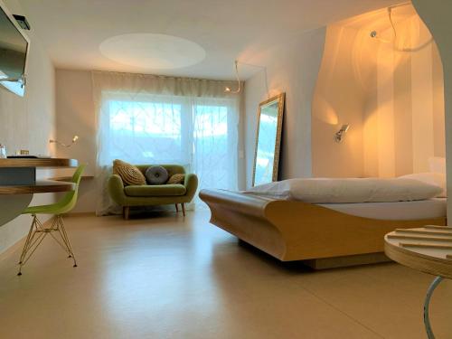路德维希堡hotelmärchen Garni的一间卧室配有一张大床和一把椅子