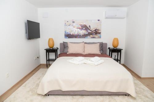 萨格勒布Dreamy Garden Zagreb的一间卧室配有一张带2个床头柜的大型白色床