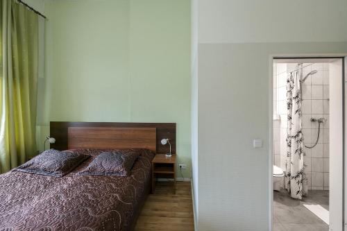 柏林潘森克拉斯科酒店的一间卧室配有一张床,浴室设有淋浴。