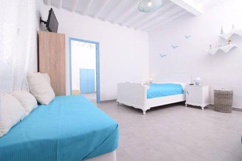 帕罗奇亚Old Town Traditional House的白色卧室设有蓝色的床和窗户