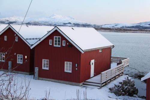 莱克内斯Rorbu Skreda的屋顶上积雪的红色房子