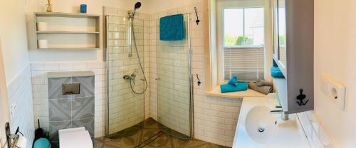 赖因伯伦Sunny Corner Holiday Apartment的带淋浴和盥洗盆的浴室