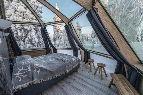 索特Syöte Igloos的冰屋的雪覆盖山脉中设有一张床的客房