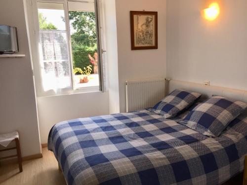 TouvoisGîte climatisé de La Haute Rue的一间卧室配有一张带蓝白色 ⁇ 面毯的床