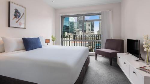 奥克兰Auckland Harbour Suites的一间设有大床和窗户的酒店客房