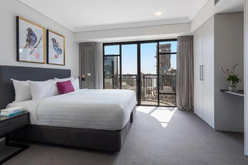 奥克兰Avani Metropolis Auckland Residences的一间卧室设有一张大床和一个大窗户