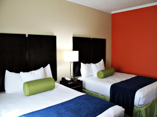 圣安东尼奥市景水中央套房酒店的酒店客房设有两张床和红色的墙壁。