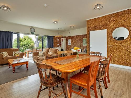 凯库拉巴纳瑟尔贝尔斯山林小屋的厨房以及带木桌和椅子的客厅。