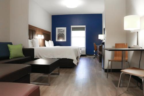 迈尔斯堡戴斯酒店及套房- 靠近捷蓝公园的酒店客房,配有床和沙发