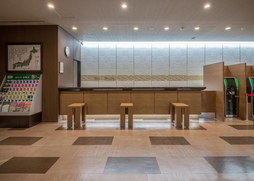 旭川旭川站前路线酒店的一间设有两个长椅和柜台的餐厅