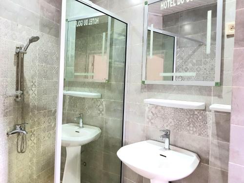 科纳克里Hotel du Golfe de Guinée的一间带两个水槽和玻璃淋浴间的浴室