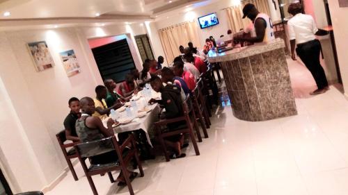 科纳克里Hotel du Golfe de Guinée的一群坐在餐厅桌子上的人