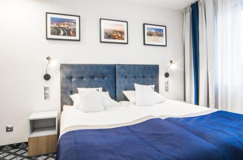 格但斯克Hotel Urbi的一间卧室配有一张带蓝色毯子的大床