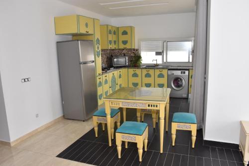 古莱比耶Arabesque Style - 2 appartements的黄色的厨房配有桌椅和冰箱